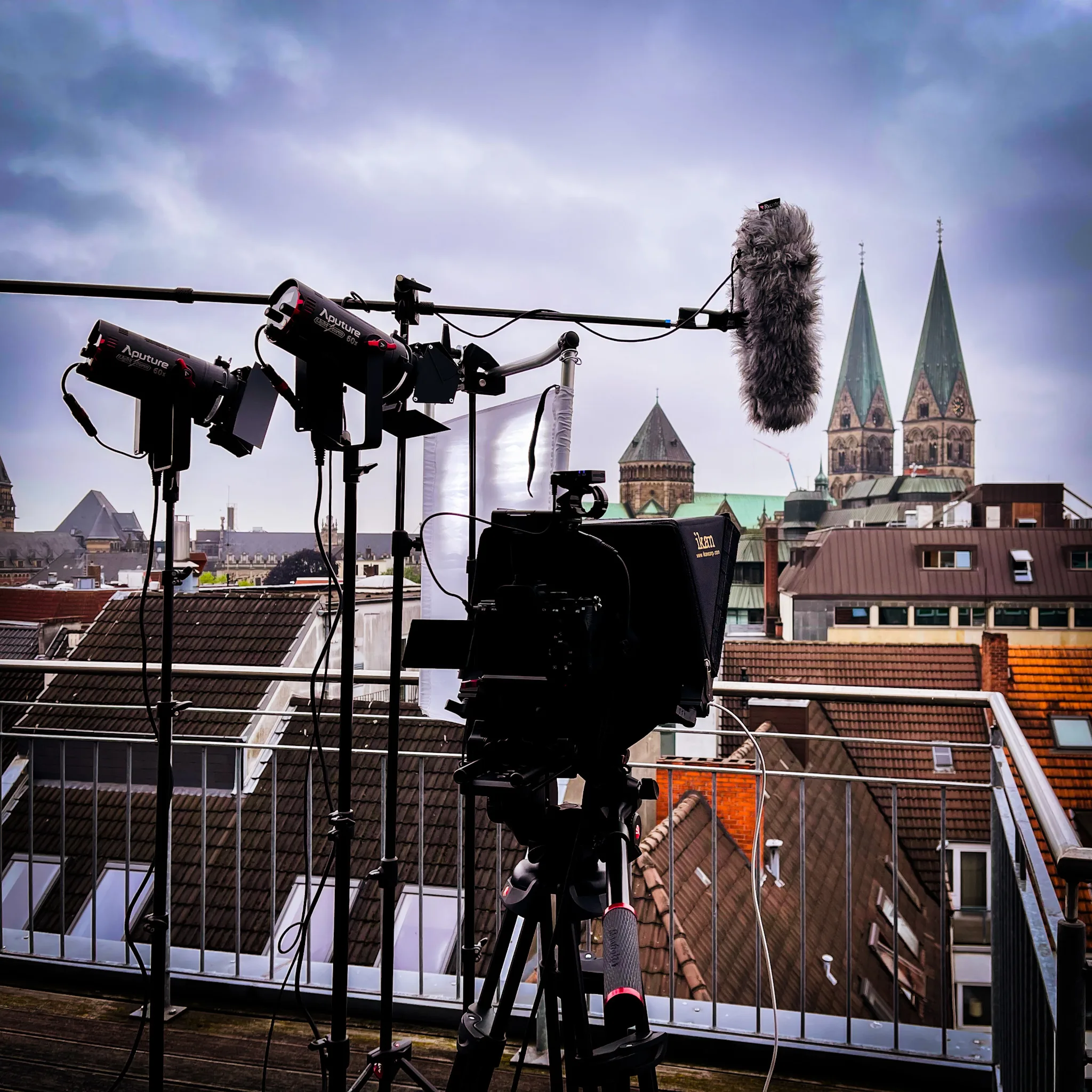 Filmdreh in Bremen: Kamera und Licht auf einem Dach, im Hintergrund die Türme des St.-Petri-Doms